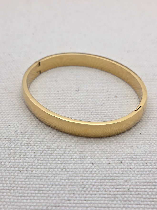 Brazalete dorado fino con diseño simple y cierre oculto