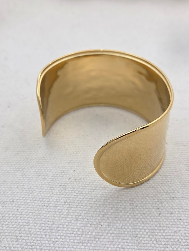 Vista alternativa del brazalete dorado abierto para ajustar