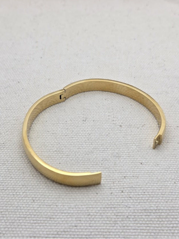 Pulsera dorada abierta por la mitad – muestra del sistema de cierre