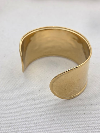 Vista alternativa del brazalete dorado abierto para ajustar