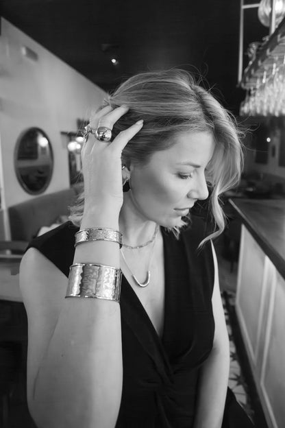 Mujer con joyas doradas Helou Bijoux en ambiente nocturno