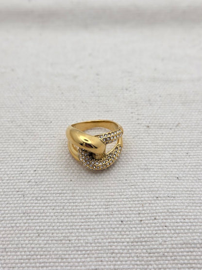 Vista frontal de anillo dorado con cristales y diseño anudado
