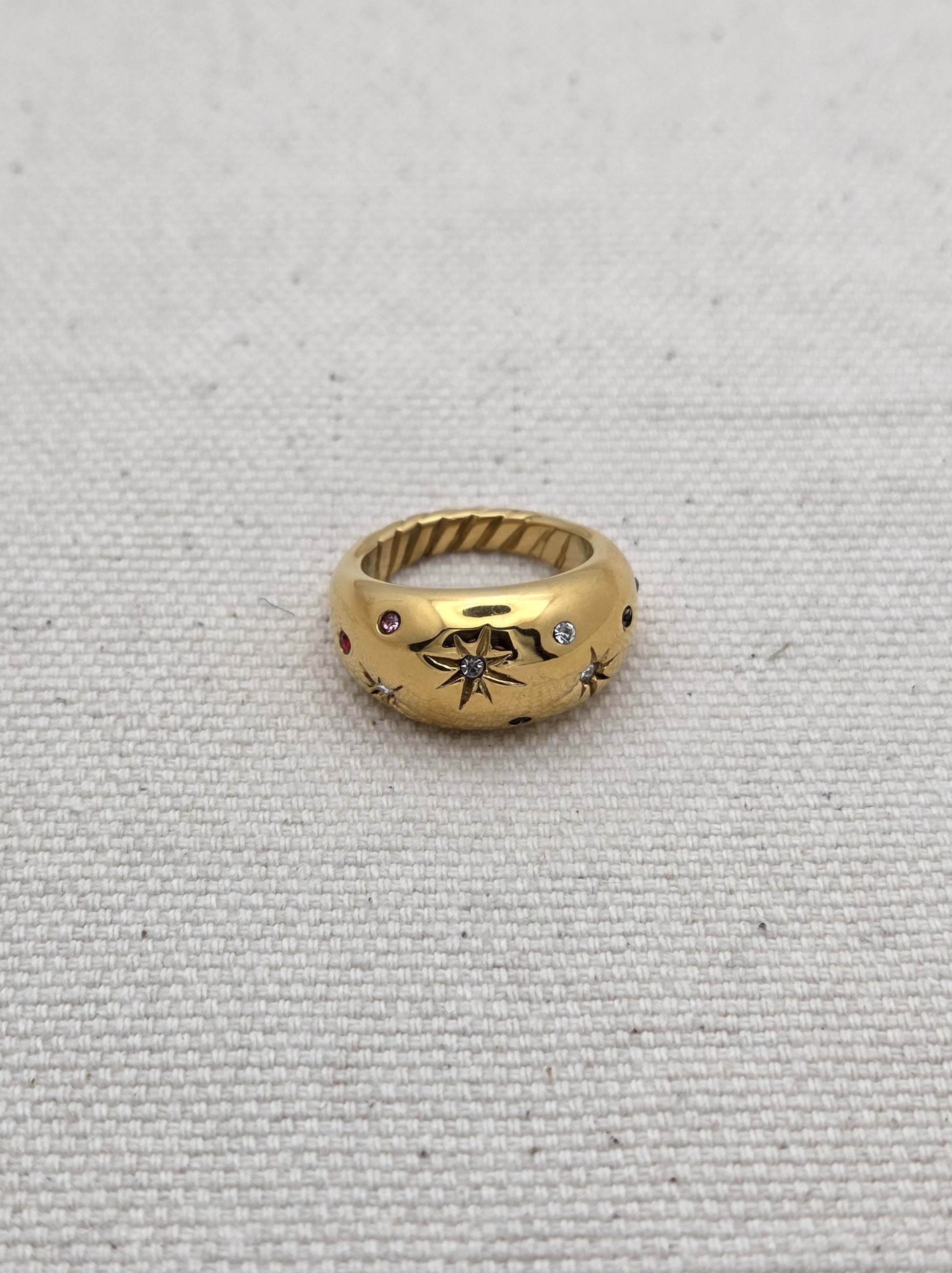 Anillo dorado ancho con grabados de estrellas y piedras de colores