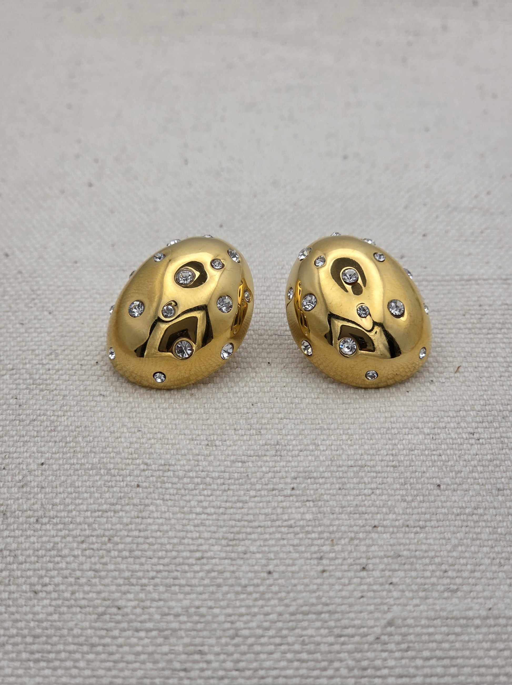 Pendientes dorados ovalados con cristales brillantes